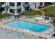 Resort style swimming pool next to the ocean with lounge chairs, tables, and beautiful landscaping at 627 Alhambra Rd # 1103, Venice, FL 34285