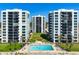 Lovely swimming pool surrounded by luxurious beachfront condo buildings and manicured lawns at 627 Alhambra Rd # 1103, Venice, FL 34285