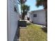 Side of the home featuring lush grass, white gravel, palm trees and an air conditioning unit at 638 Leisure, Venice, FL 34285