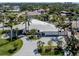 Elegant home exterior with a circular driveway, mature palm trees, and well-maintained landscaping at 701 Laguna Dr, Venice, FL 34285