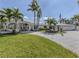 Sprawling single-story home boasts verdant lawn, paved driveway, and palm-lined landscaping at 701 Laguna Dr, Venice, FL 34285