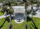 Impressive property with a circular driveway, a classic fountain, and lush palm trees in a landscaped lawn at 701 Laguna Dr, Venice, FL 34285