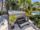 Tranquil hot tub area surrounded by lush landscaping, with potted plants and patio stones at 701 Laguna Dr, Venice, FL 34285