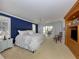 Bright main bedroom with a king bed, neutral carpet and sliding door access to outdoor patio at 701 Laguna Dr, Venice, FL 34285