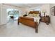 Inviting main bedroom featuring tile floors, large bed and an outside view of the pool at 701 Laguna Dr, Venice, FL 34285