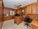 Spacious home office with wood paneled walls, built-in cabinetry and ceiling fan at 701 Laguna Dr, Venice, FL 34285