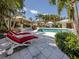 Luxurious backyard oasis features sparkling pool, sun loungers, and covered lounge areas at 701 Laguna Dr, Venice, FL 34285
