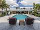 Relaxing backyard with in-ground pool, lounge chairs, and tropical landscaping under a sunny sky at 701 Laguna Dr, Venice, FL 34285