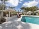 In-ground pool with gazebo and lounge seating surrounded by lush, mature landscaping in a private backyard at 701 Laguna Dr, Venice, FL 34285