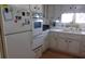 White kitchen with an oven, refrigerator, window, and laminate floors at 722 Carefree, Venice, FL 34285