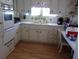 Bright kitchen featuring white cabinets, laminate wood flooring and a double basin sink at 722 Carefree, Venice, FL 34285