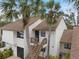 Charming two-story condo with palm trees and a wooden staircase leading to the front door at 758 Bird Bay W Dr # 169, Venice, FL 34285