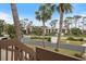 View of condo buildings from the stairs through palm trees at 758 Bird Bay W Dr # 169, Venice, FL 34285