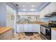 Well-lit kitchen with white cabinets, stainless steel oven, and a view into the dining area at 758 Bird Bay W Dr # 169, Venice, FL 34285