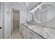Bathroom featuring double round mirrors, updated lighting and vanity with a granite countertop at 764 Avenida Estancia # 212, Venice, FL 34292