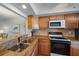 Features stainless steel appliances, wooden cabinets, and a decorative tile backsplash at 764 Avenida Estancia # 212, Venice, FL 34292