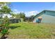 The backyard features a screened pool area, storage sheds, and well-maintained lawn at 888 Kimball Rd, Venice, FL 34293