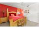 Spacious bedroom with a red accent wall, light wood bed, and tiled floors at 888 Kimball Rd, Venice, FL 34293
