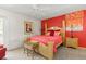 Bright bedroom with a red accent wall, light wood furnishings, and a ceiling fan at 888 Kimball Rd, Venice, FL 34293