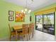Bright dining room featuring a light fixture, tile flooring, and a view of the screened in patio at 888 Kimball Rd, Venice, FL 34293