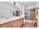 Bright bathroom features double vanity, updated lighting fixtures, and glass-enclosed shower at 9413 Carnaby Dr, Venice, FL 34293