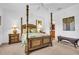 Spacious main bedroom with four-poster bed, ceiling fan, and neutral carpeting at 9413 Carnaby Dr, Venice, FL 34293