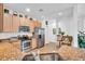 Modern kitchen featuring stainless steel appliances, granite countertops, and ample cabinet space for storage and meal preparation at 9413 Carnaby Dr, Venice, FL 34293