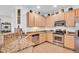 Well-equipped kitchen featuring stainless steel appliances and tiled floors at 9413 Carnaby Dr, Venice, FL 34293