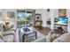Bright and airy living room featuring comfortable seating and a view of the outdoors through sliding glass doors at 9413 Carnaby Dr, Venice, FL 34293
