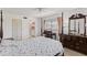 Bright bedroom featuring a four-poster bed, desk, and dresser, providing ample space for relaxation at 942 Capri Isles Blvd # 105, Venice, FL 34292
