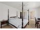 Spacious bedroom with four-poster bed, neutral carpet and en-suite bathroom access at 942 Capri Isles Blvd # 105, Venice, FL 34292