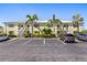 Two-story yellow condo building with palm trees, parking, and well-maintained landscaping at 942 Capri Isles Blvd # 105, Venice, FL 34292