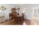 Traditional dining room features wood floors, dining table, and a pass-through window to the kitchen at 942 Capri Isles Blvd # 105, Venice, FL 34292