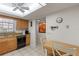 Functional kitchen with warm cabinets, granite countertops, and adjacent dining area at 942 Capri Isles Blvd # 105, Venice, FL 34292