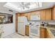Functional kitchen features wooden cabinets, a classic white refrigerator and plenty of storage at 942 Capri Isles Blvd # 105, Venice, FL 34292