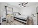 This bedroom boasts a modern ceiling fan, bedside table, and ample natural light at 10047 Greetings St, Port Charlotte, FL 33981