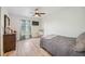 Bedroom featuring light grey floors, a ceiling fan, and a window with sheer curtains at 10047 Greetings St, Port Charlotte, FL 33981
