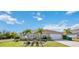 Charming single-story home with well-manicured lawn, complemented by young palm trees, and a two car garage at 10047 Greetings St, Port Charlotte, FL 33981