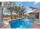 Relaxing screened-in pool with sparkling blue water, a spa, and a spacious surrounding patio at 10047 Greetings St, Port Charlotte, FL 33981
