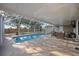 Inviting screened-in pool with a spacious deck, ideal for outdoor relaxation and entertaining, wicker furniture, and an outdoor grill at 10047 Greetings St, Port Charlotte, FL 33981