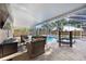 Screened pool and spa area with brick pavers and outdoor seating area at 10047 Greetings St, Port Charlotte, FL 33981