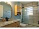 Bright bathroom featuring a marble tile shower, granite vanity, and mirrored medicine cabinet at 1008 Euclid Rd, Venice, FL 34293