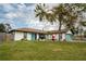 Charming single-story home featuring a bright turquoise garage door and entry with lawn decor at 1008 Euclid Rd, Venice, FL 34293