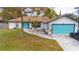 Charming single-story home featuring a bright turquoise garage door and entry in a well-maintained yard at 1008 Euclid Rd, Venice, FL 34293
