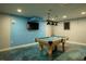 A finished basement game room with a pool table, TV, and custom epoxy flooring offers a great entertaining space at 1008 Euclid Rd, Venice, FL 34293