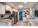Bright kitchen boasts white cabinets, granite countertops, stainless appliances, and convenient access to the game room at 1008 Euclid Rd, Venice, FL 34293