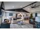Coastal-themed living room featuring vaulted ceiling, tile floors, modern furnishings, and an open layout to the kitchen at 1008 Euclid Rd, Venice, FL 34293