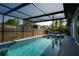 Backyard featuring a beautifully designed pool, jacuzzi, and screened patio area at 1008 Euclid Rd, Venice, FL 34293