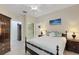 Bedroom with a ceiling fan, light wood floors, a dark wood dresser, and a view into the closet at 11007 Batello Dr, Venice, FL 34292