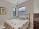 Bright bedroom with two windows, a decorative bedspread, and neutral wall paint at 11007 Batello Dr, Venice, FL 34292
